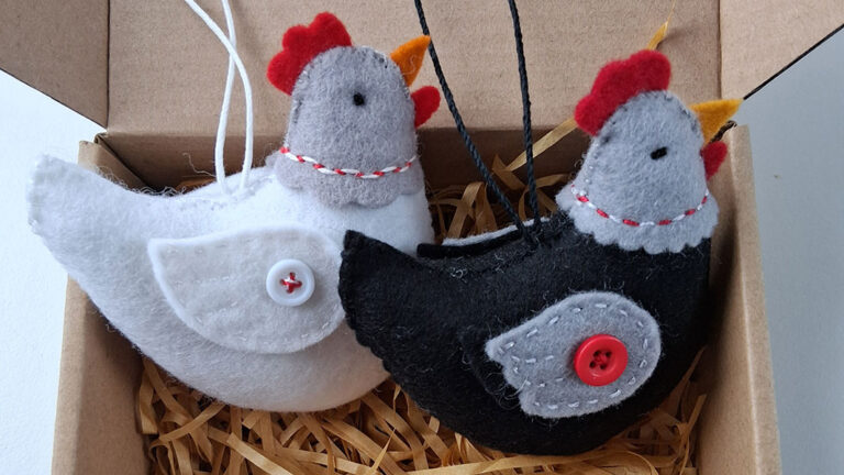 Two mini hen hanging decorations in a cardboard box from Flora Patterns.